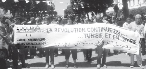 Delegacin de Lucha Internacionalista y de la UIT-CI en la movilizacin de trabajadores tunecinos del 1 de Mayo, en la capital de Tnez, luego de realizada la reunin de Regued, en apoyo a la lucha del pueblo sirio. La pancarta dice La revolucin sigue en Tnez y en Siria (en frances y rabe). De izquierda a derecha Pepe Daz, Cristina Mas, Marga Olalla, Pablo Medina (de Lucha Internacionalista del estado Espaol), y Miguel Sorans, de la Unidad Internacional de los Trabajadores (UIT-CI)-.